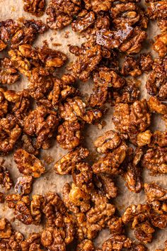 closeup of walnuts that have been roasted and are ready to be eaten on a sheet of parchment paper