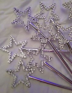 some silver colored metal pins and needles on a white sheet with beaded stars in the middle