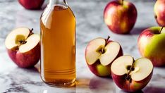 an apple cider with apples in the background