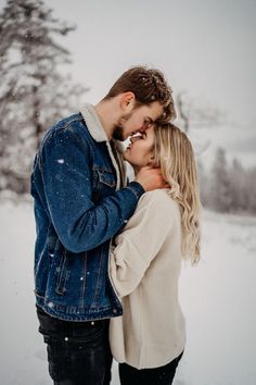 a man and woman kissing in the snow