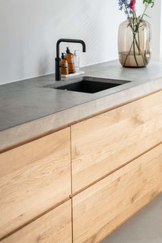 a kitchen counter with a sink and some flowers