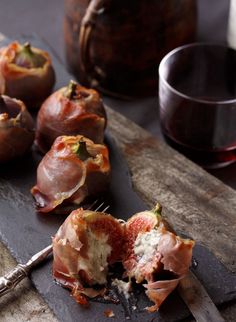 some food that is on top of a cutting board next to a glass of wine