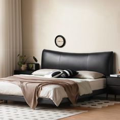 a bedroom with a bed, night stand and nightstands in black leatherette finish