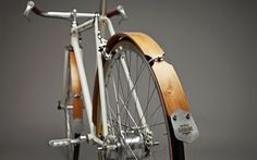 an old fashioned bicycle with wooden spokes and wheels is shown in this image, it's attached to the back wheel