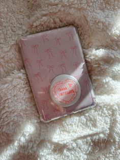 a pink and white teddy bear themed package on top of a fluffy blanket with the words hello kitty printed on it