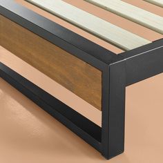 a bed frame with wooden slats and metal support bars on the bottom, against a tan background