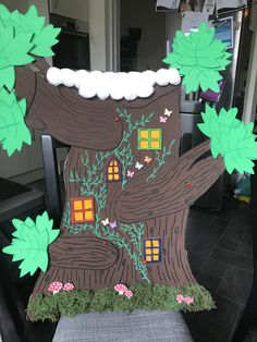 a paper cutout of a tree house with green leaves on it's side