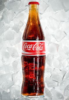 a bottle of coca cola sitting on top of ice