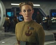 a woman in a star wars outfit standing in front of a machine room with other people