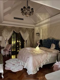 a bedroom with a large bed and chandelier