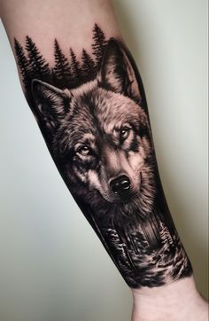 an arm with a wolf and trees on it