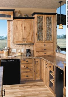 a kitchen with wooden cabinets and an island in front of a window that looks out onto the water