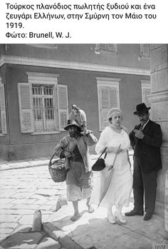 an old black and white photo shows two people standing next to each other on the sidewalk