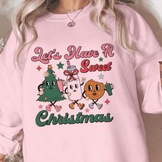 Indulge in the sweetness of the holidays with our 'Festive Delight 'Sweet Christmas' Sweatshirt'! With an adorable design featuring festive characters, it's perfect for holiday gatherings or just adding a touch of cheer to your winter wardrobe. Proudly handcrafted by our small business, this sweatshirt comes in an assortment of colors and sizes to fit your holiday celebration. Visit our website to find the perfect color and size for your festive season style! Please choose between long sleeve t Cute Holiday Crew Neck Sweatshirt, Cute Crew Neck Sweatshirt For Holiday, Cute Winter T-shirt For Loungewear, Cute Christmas Sweatshirt With Letter Print, Sweet Crew Neck Top For Fall, Sweet Fall Crew Neck Top, Cute Holiday Graphic Print Tops, Cute Christmas Graphic Print Sweatshirt, Cute Christmas Sweatshirt With Graphic Print