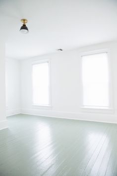 an empty room with white walls and wood floors