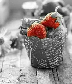 two strawberries sitting in a cup on a table