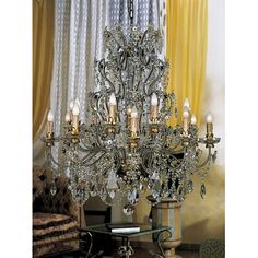 a crystal chandelier in a living room with yellow drapes on the windowsill