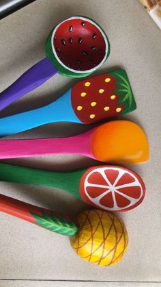 colorful wooden spoons with fruit and vegetables on them