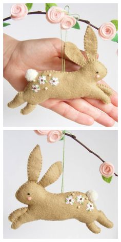 a hand holding a small stuffed animal hanging from a tree branch with flowers on it