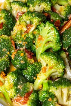 broccoli and other vegetables are mixed together in a dish with chopsticks