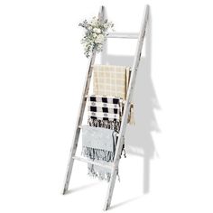 a white ladder with towels and flowers on it