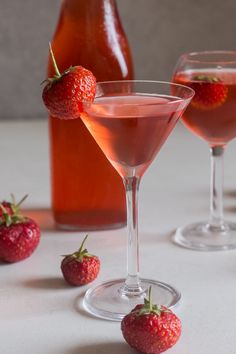 two glasses filled with pink liquid and strawberries