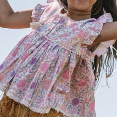 - Brand: Spell & The Little Gypsies - 'Folk Town' Blouse - Size: 6y - Tassel - Button Closure - Lace Hem - Flutter Sleeves - Floral Print - Color: Springtime - 100% Organic Cotton - Approx. Length From Shoulder: 16" - Blouse Will Come Wrinkled This Spell & The Little Gypsies 'Folk Town' Blouse Comes New Without Tags Attached & Comes From A Pet/Smoke Free Home. Pink Cotton Top For Play, Pink Cotton Tops For Play, Summer Pink Flutter Sleeve Tops, Pink Summer Top For Play, Cute Pink Top For Playdate, Bohemian Pink Tops With Ruffles, Pink Tops For Summer Playdate, Pink Bohemian Cotton Top, Cotton Flutter Sleeve Tops For Playtime