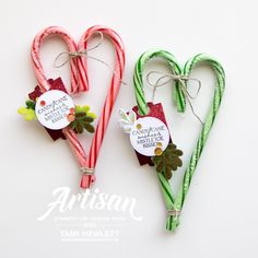 two candy canes shaped like hearts with tags on them