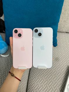 two pink and white iphones sitting next to each other on top of a couch