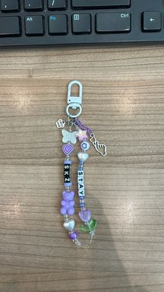 a keychain with beads and charms attached to it on top of a computer keyboard