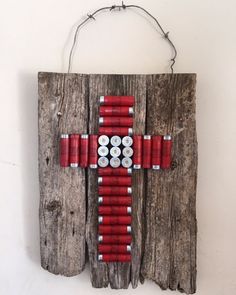 a cross made out of cans on a piece of wood