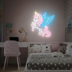 a child's room with a bed, desk and unicorn wall decal on the wall