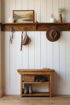 a wooden bench sitting under a shelf next to a hat rack and coat rack with hats on it