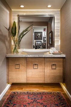 a bathroom with a rug, sink and mirror on the wall next to an area rug