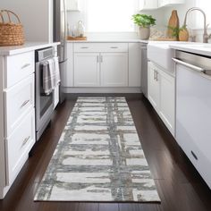 a kitchen with white cabinets and wood flooring next to an oven, dishwasher and microwave