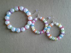 Earring and bracelet set that I made for a little girl... Made with multi-color plastic spacer beads and white pearl beads.  Measurements: Earrings are a little over 2 inches in length and 1.5 inches in width. Bracelet is about 8 inches circumference.  Thanks for looking :-) White Plastic Beaded Bracelets, Handmade White Plastic Beaded Bracelets, White Pearl Bracelet With Spacer Beads, Plastic Bead Jewelry For Birthday, Playful White Hypoallergenic Jewelry, Playful Handmade White Jewelry, Handmade White Pearl Bracelet For Birthday, Handmade Playful White Jewelry, Playful White Handmade Jewelry