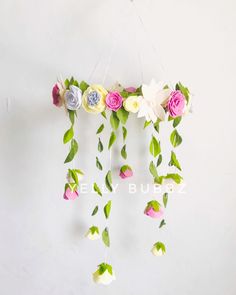 a mobile with flowers hanging from it's sides