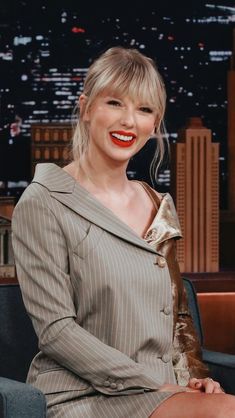 taylor swift on the tonight show with her red lips and hair in a messy updo