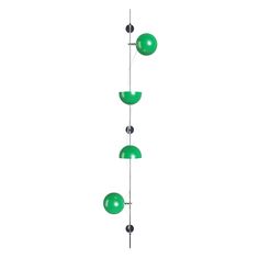 three green glass balls hanging from a metal pole on a white background with black dots