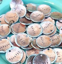 a blue bowl filled with lots of different types of metal tags on top of each other