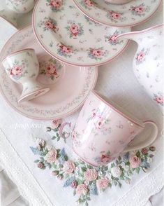 a table topped with plates and cups filled with flowers