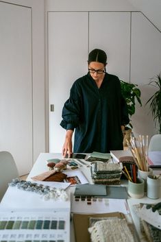 a man standing in front of a table filled with art supplies