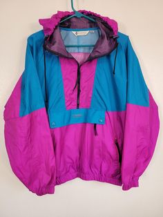 Talk about a 90's flashback! It's a Vintage 1990s Columbia fuchsia / blue color block kangaroo pocket hooded unlined nylon batwing anorak pullover! Tag women's XL Packable, metal front snaps. Sheer, shiny fabric. And it's as close to unworn condition as I've ever seen, it's spectacular with no wear, rips, stains, holes, etc.  Please see our other listings for more vintage garments with new items added nearly daily. PLEASE check the measurements as vintage clothing sizes may not comparable to contemporary sizes. Measurements: Label size: extra large Shoulder-to-shoulder: 22" Chest across: 29" Sleeve from shoulder: 20" Length in back from base of collar: 26" LadyObsolete is smoke-free. We present garments as honestly as possible and point out any known flaws. We leave cleaning and/or repair Cheap Oversized 90s Outerwear, Cheap Vintage Spring Windbreaker, Vintage Purple Windbreaker For Outdoor, 90s Hooded Windbreaker For Hiking, 90s Purple Hooded Windbreaker, Retro Hooded Windbreaker For Hiking, 90s Color Block Windbreaker For Outdoor, Retro Pink Hooded Windbreaker, Pink Retro Hooded Windbreaker