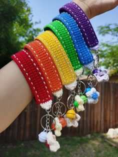 a person is holding several crocheted bracelets in different colors and sizes,