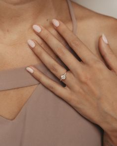 a close up of a woman's hand with a diamond ring on her finger