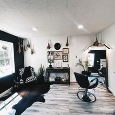 a living room filled with furniture and pictures on the wall next to a chair in front of a window