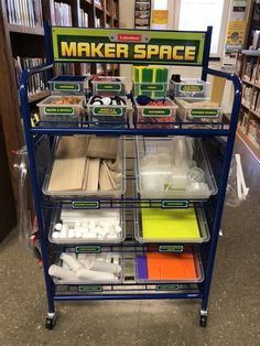 a blue cart filled with plastic containers and other items in front of a bookshelf