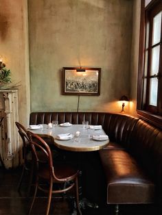 a corner booth with two chairs and a table