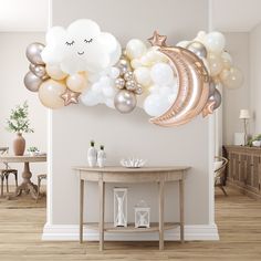 a balloon arch with stars, moon and clouds on it in the middle of a room