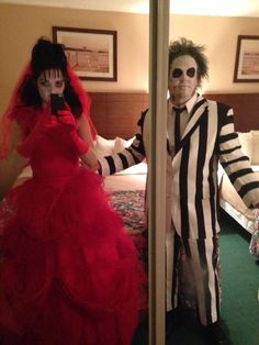 a man and woman dressed up in costumes standing next to each other on a bed